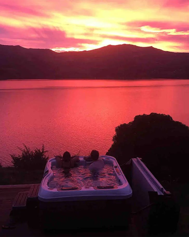 Guests enjoy the outdoor hot tub at dusk.