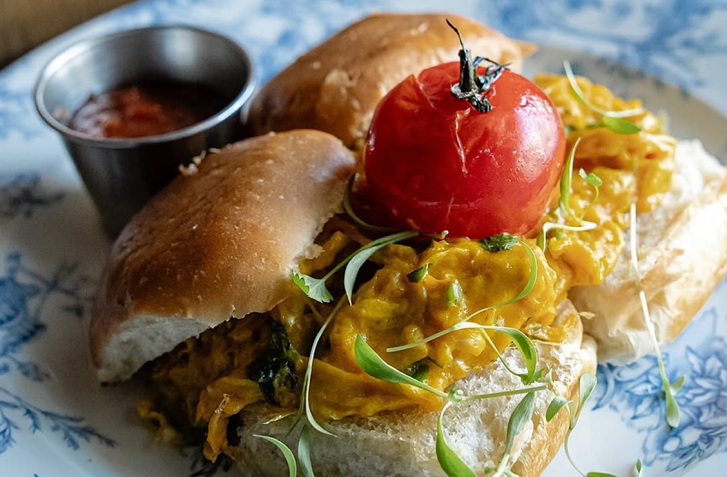 Spiced scrambled eggs in plump white buns, with grilled tomato and a tangy relish. 