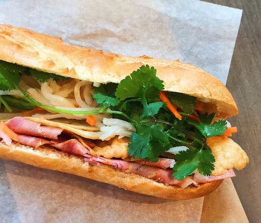 A banh mi roll on white paper