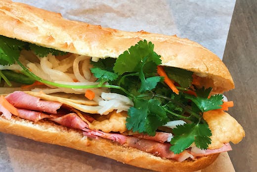 A banh mi roll on white paper