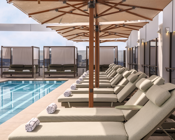 Cream coloured recliners beside the rooftop pool at The Alva Hotel in Brisbane