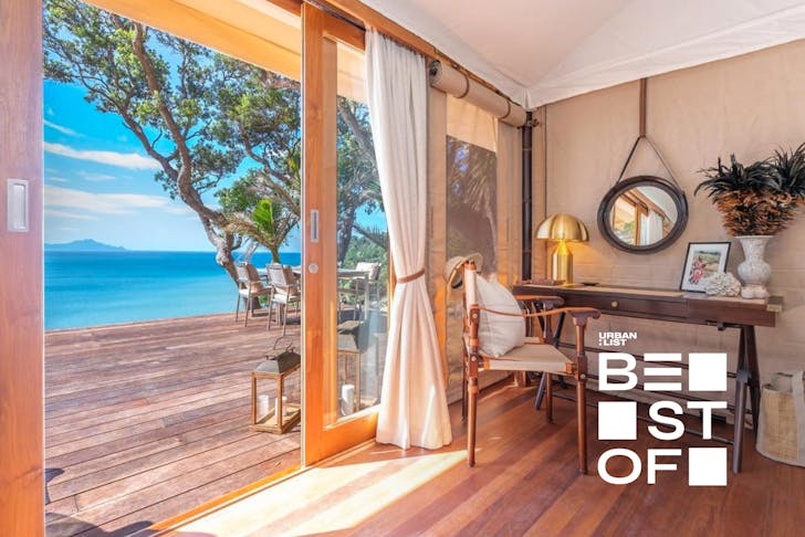 A bright room looks out onto an impossibly blue sea at Andersons Cove, one of the best romantic getaways from Auckland.