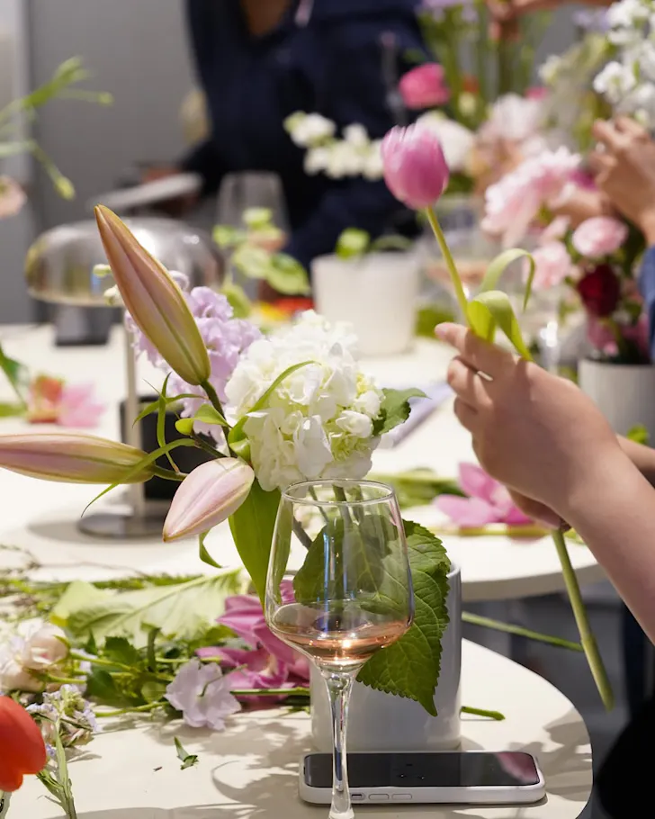 A flower workshop attendee selects flowers for a vase.