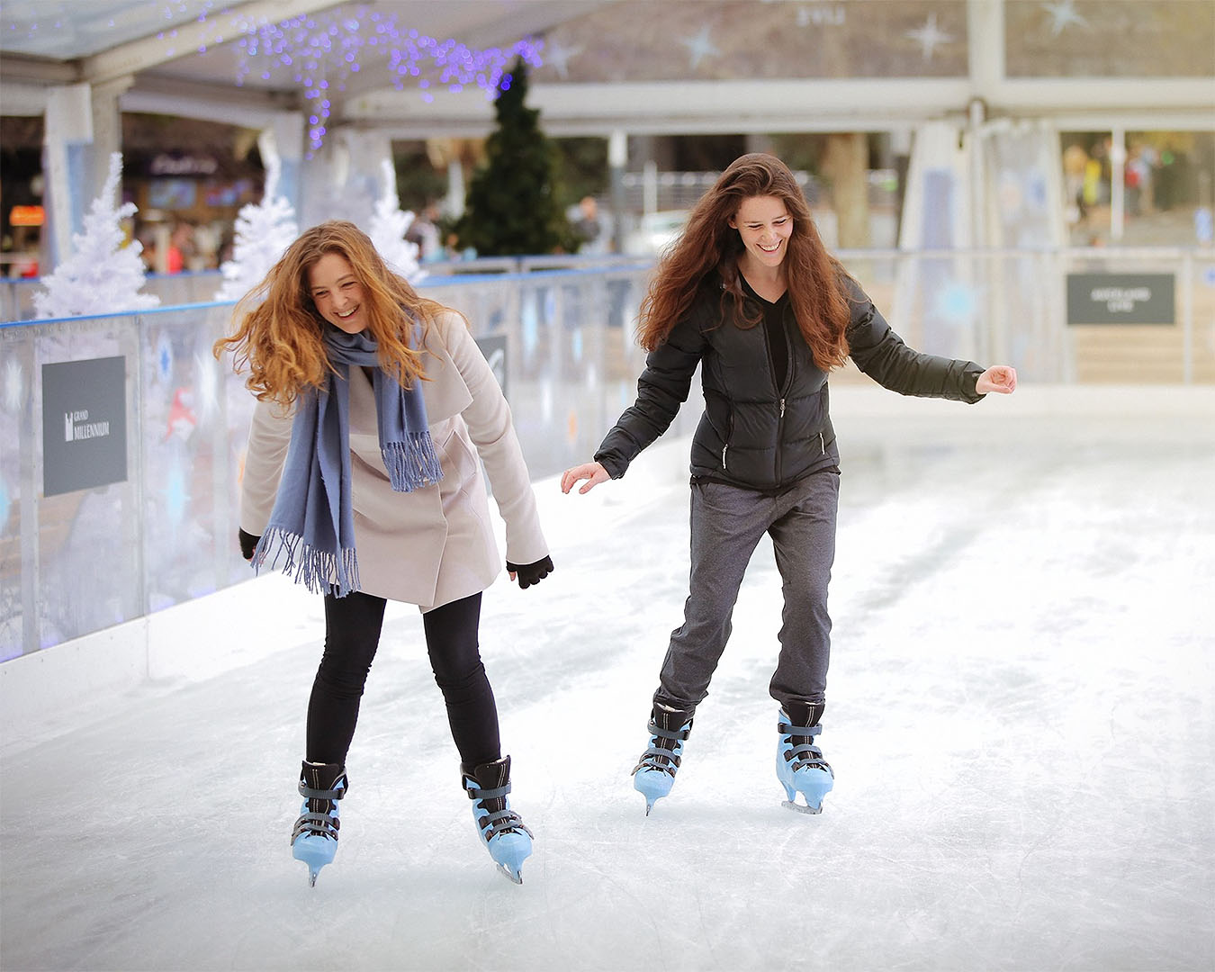Two people having fun ice skating at Aotea Square in Auckland.