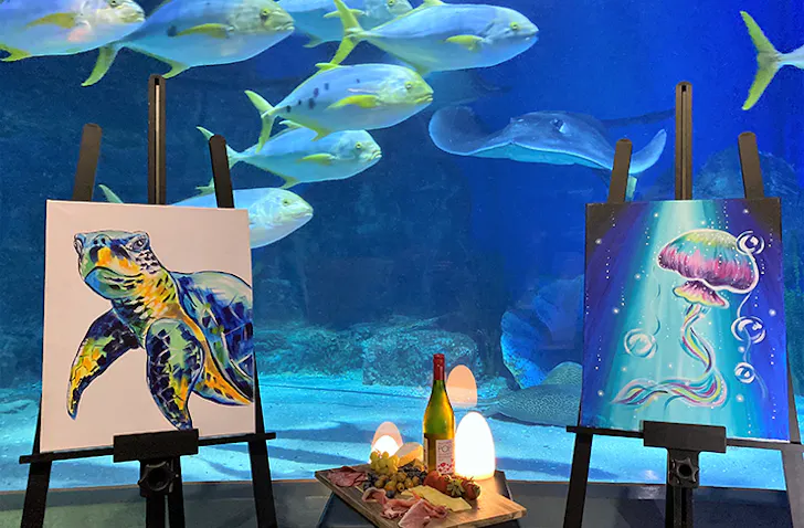 Paintings in front of an aquarium.