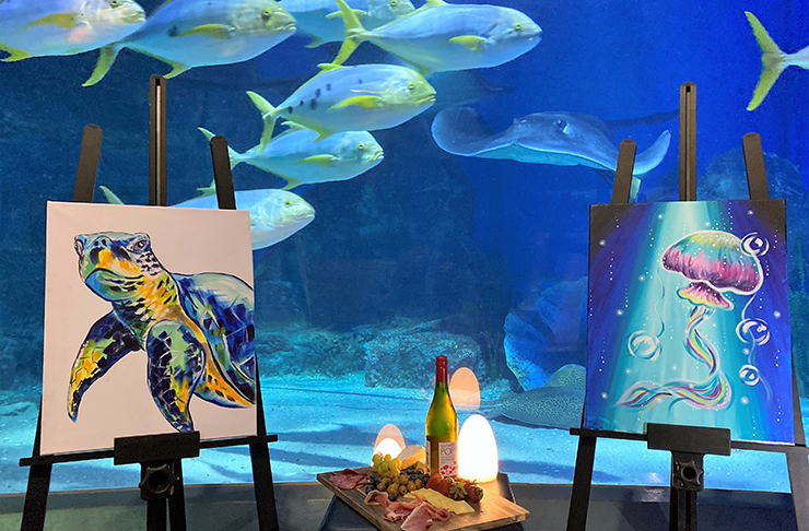 Paintings in front of an aquarium.
