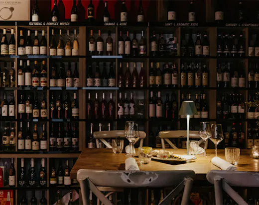 a table in front of a wall of wine