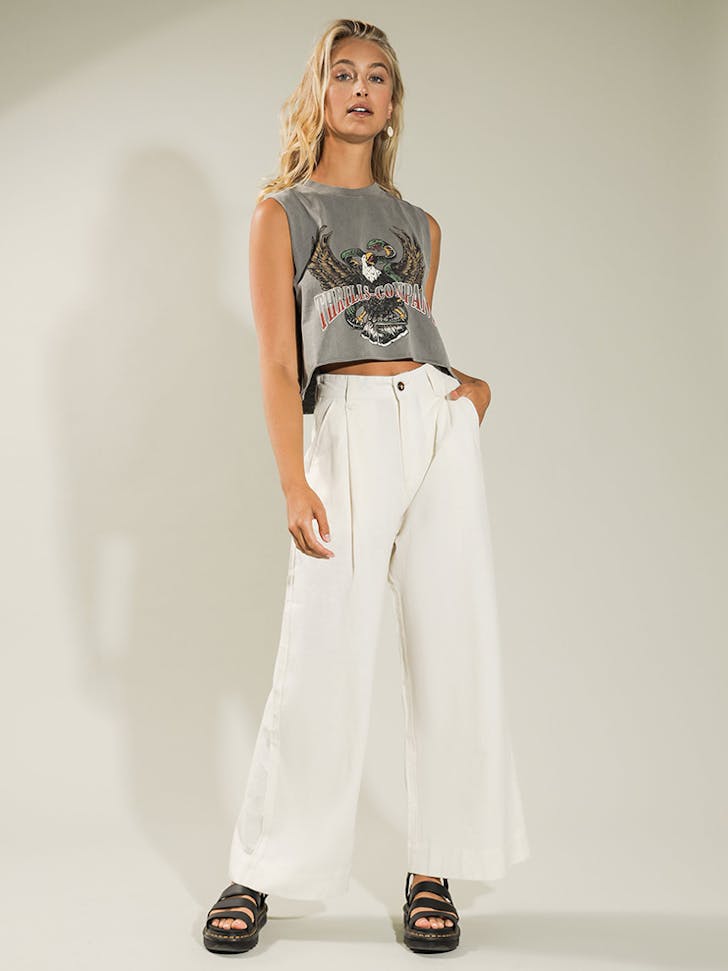 A blonde woman in white. wide-legged pants.