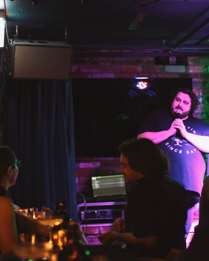 Someone performing stand-up Austin's cellar-style basement venue.