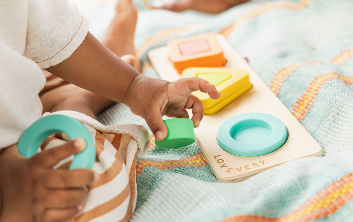 baby shower gift idea image: a baby doing a coloured puzzle