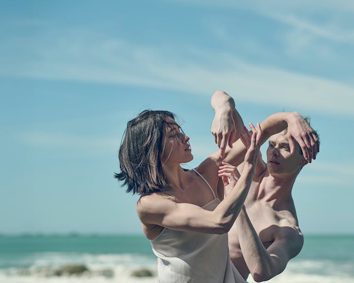 Two toned dancers from Home, Love & Sea strike an intimate pose with one another on the beach.