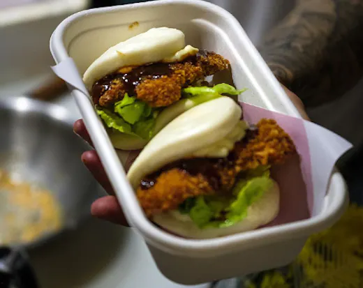 two bao buns in a takeaway container 