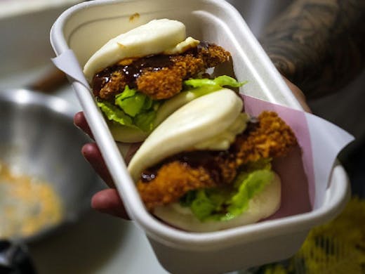 two bao buns in a takeaway container 