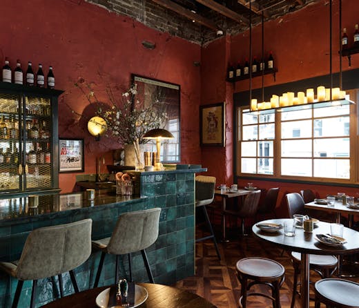 Deep red walls and accents of bottle green and brass at Bar Conte in Surry Hills. 