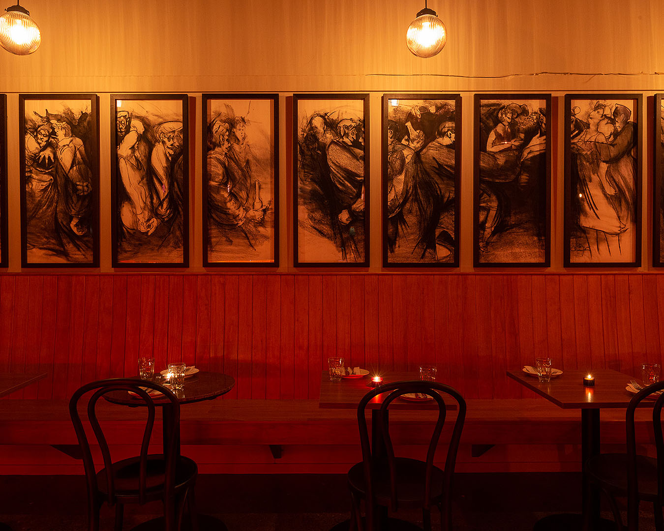 The interior at Bar Magda shows seats with impressive artwork on the wall.