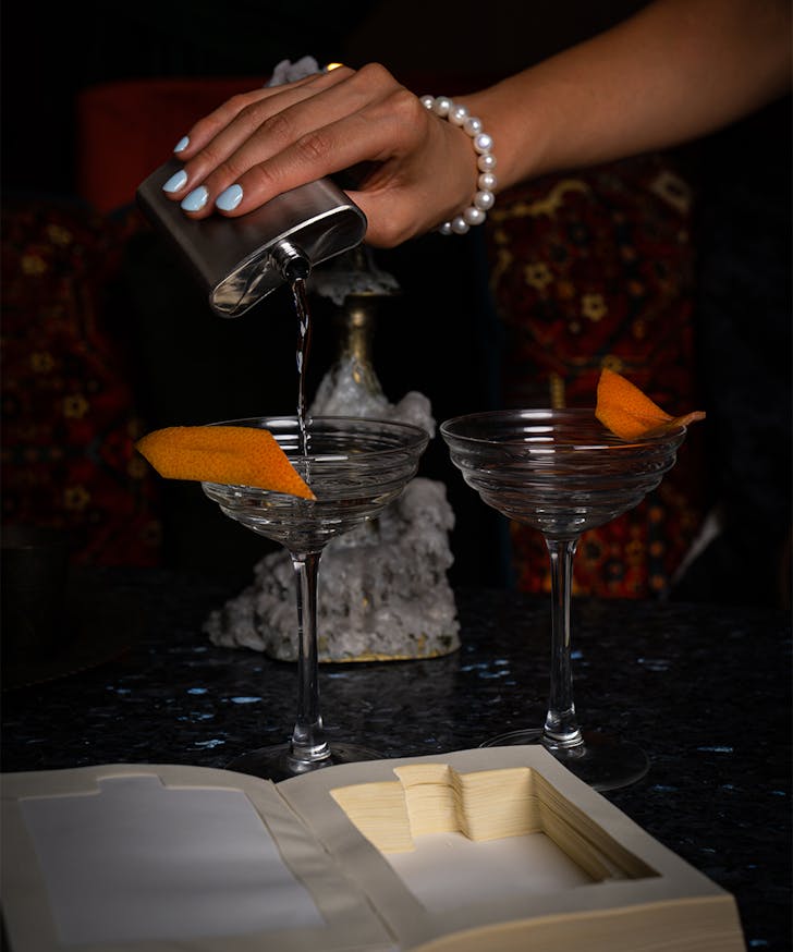 a cocktail being poured from a flask