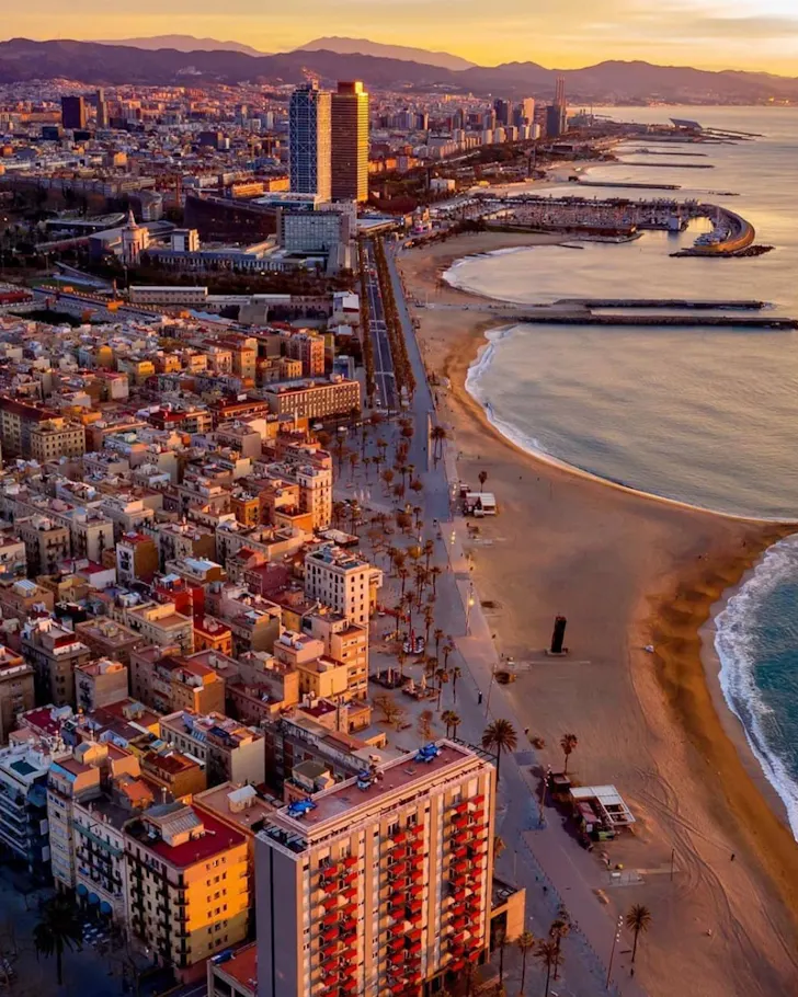 An overhead view of the Barcelona coastline at sunset.