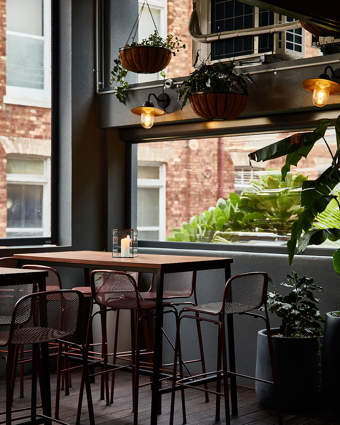 The lovely airy space that is Barcita shows high tables and lovely plants overlooking the street.