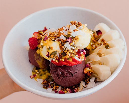 a close-up shot of an ice cream bowl dish against a pink backdrop