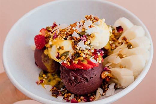 a close-up shot of an ice cream bowl dish against a pink backdrop