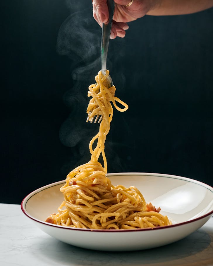 a person twirls spaghetti around a fork