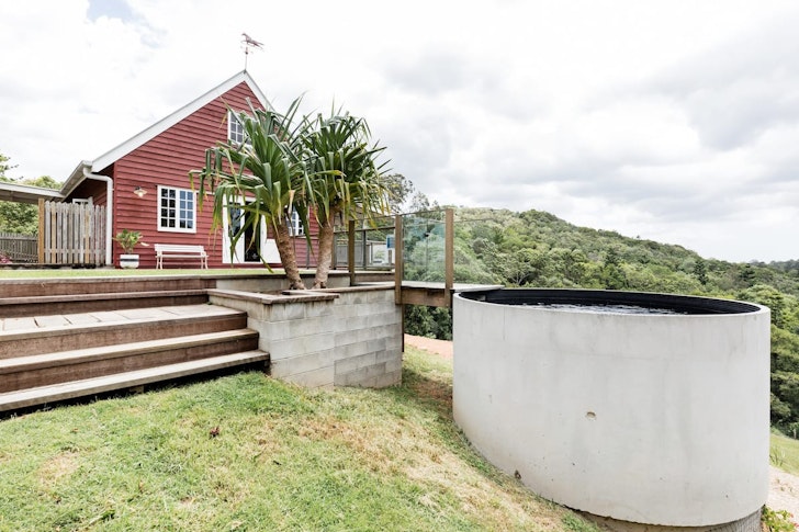 a red, barn like house with adjacent water tank