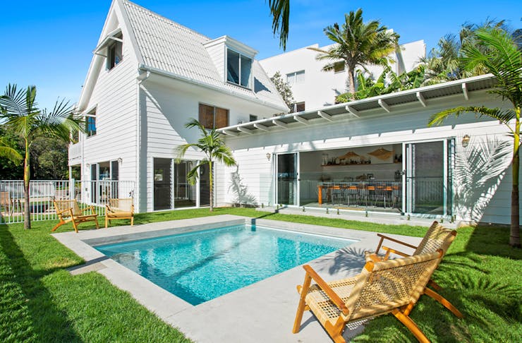 a white beach house with a pool