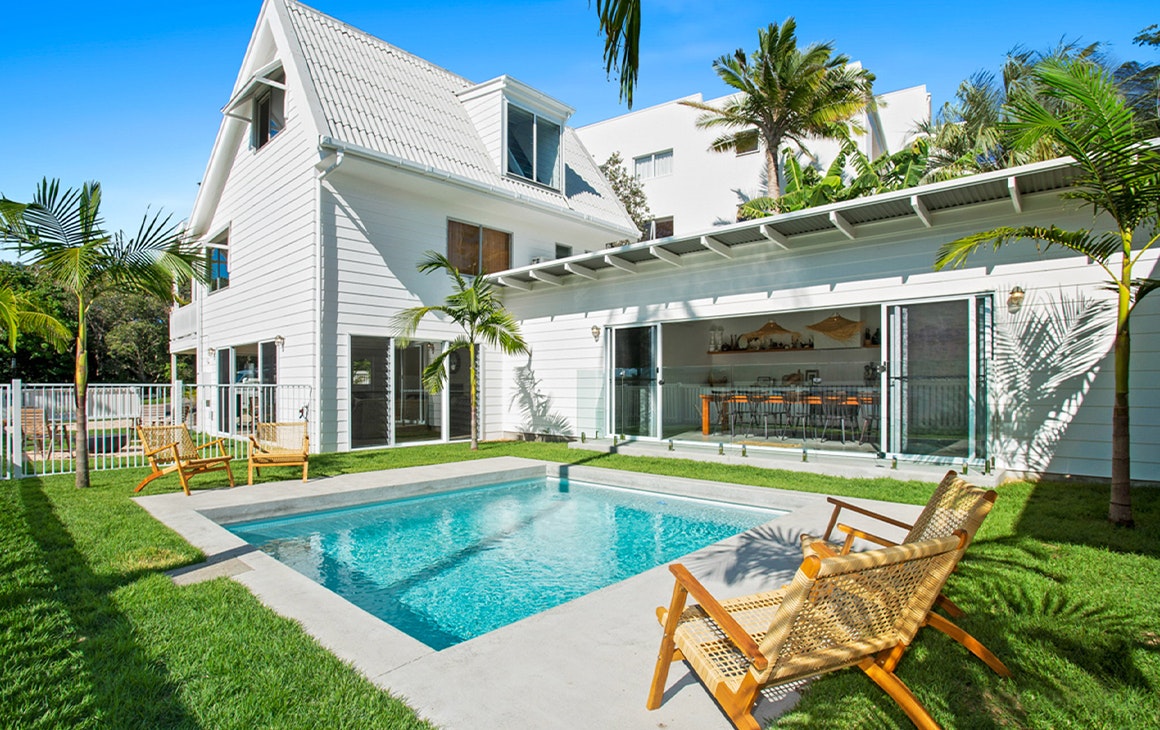 a white beach house with a pool