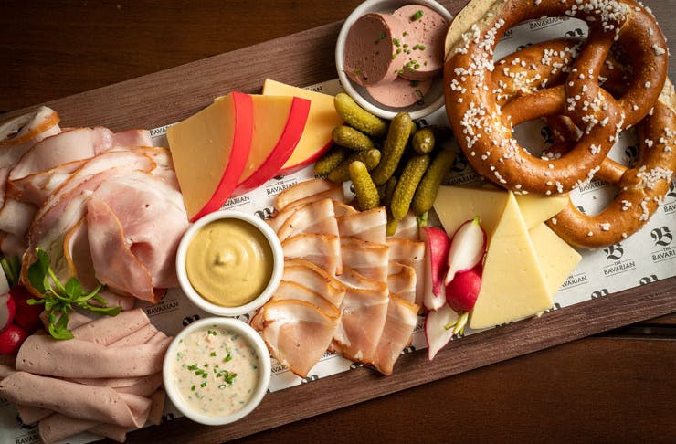 A Bavarian Bottomless Meat And Cheese Platter with pretzels. 