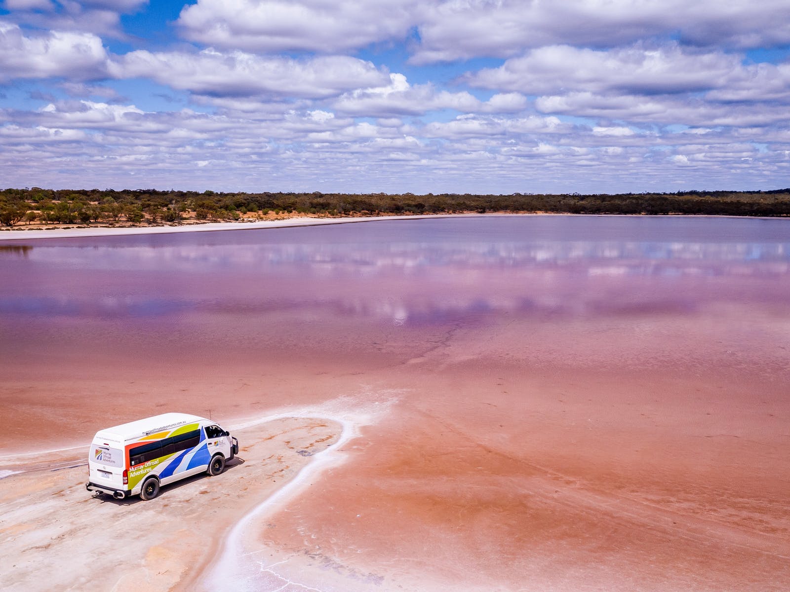 a van parked by a pink lake