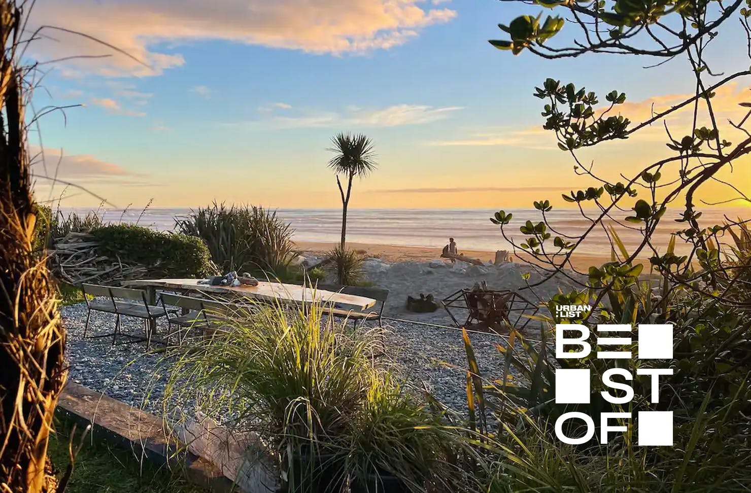 A gorgeous wooden table sits outside this peaceful Hokotika stay for outdoor, beachside dining 
