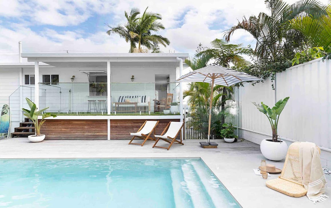 a cottage with a pool in front of it