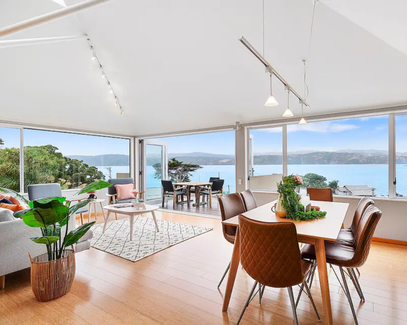 A shot of the gorgeous, open living and dining area at the Beachstay in Seatoun, including its sweeping ocean views, and this is definitely one of the best airbnbs in Wellington.