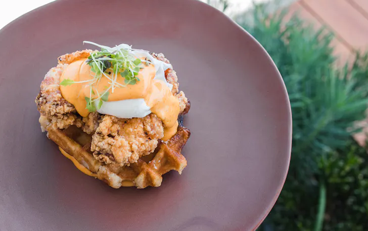 eggs benny with fried chicken on a waffle