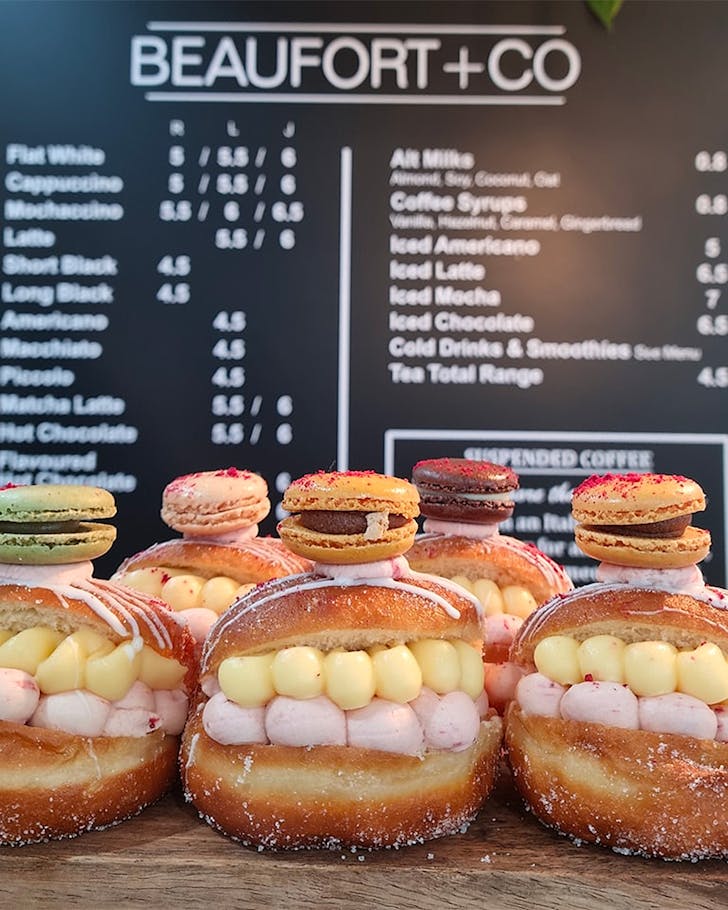 A delicious looking doughnut filled with cream and berry sauce, topped with a tuile containing more cream and berry sauce!