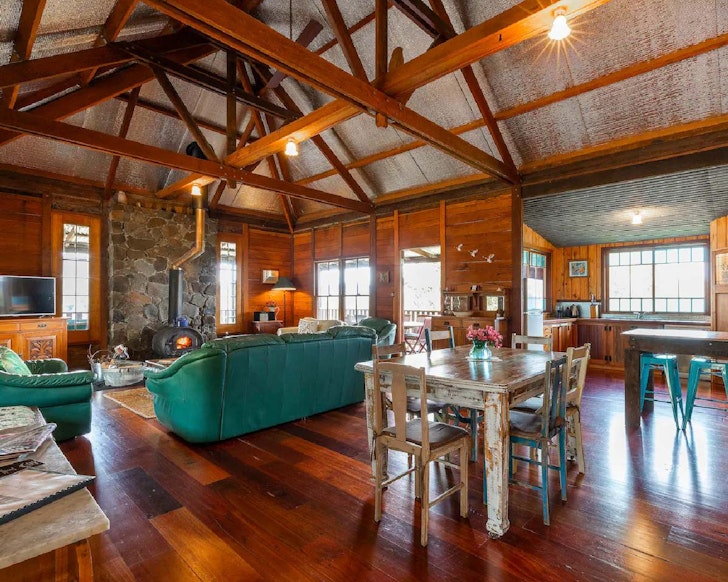 The living space at Belltree Ridge cabin near Brisbane with wood-burning fireplace