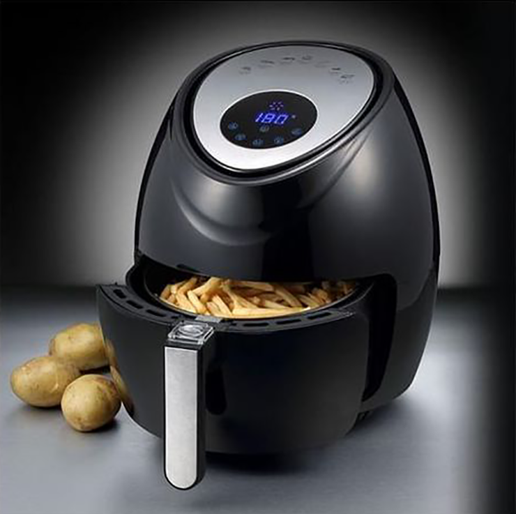 One of the best air fryers on the market cooking chicken in front of a black background.