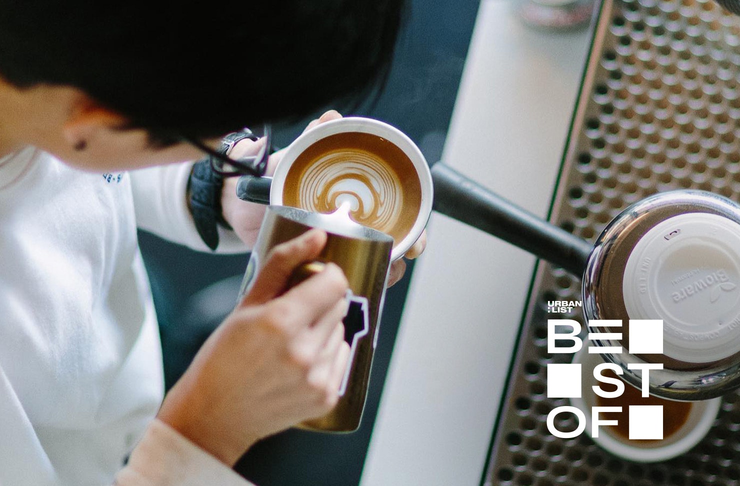 Someone makes latte art at Benedicts Cafe, one of the best spots for coffee in Auckland.