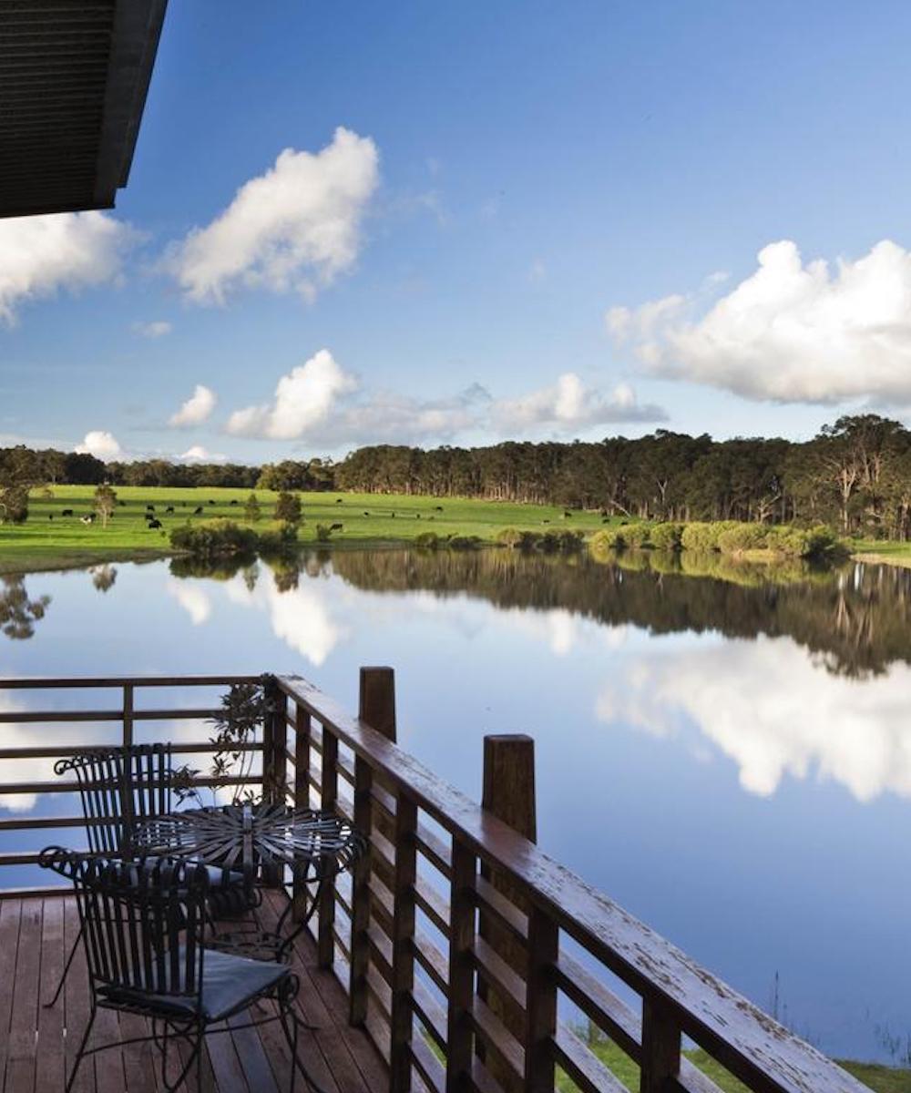 a deck overlooking a lake with table and chairs