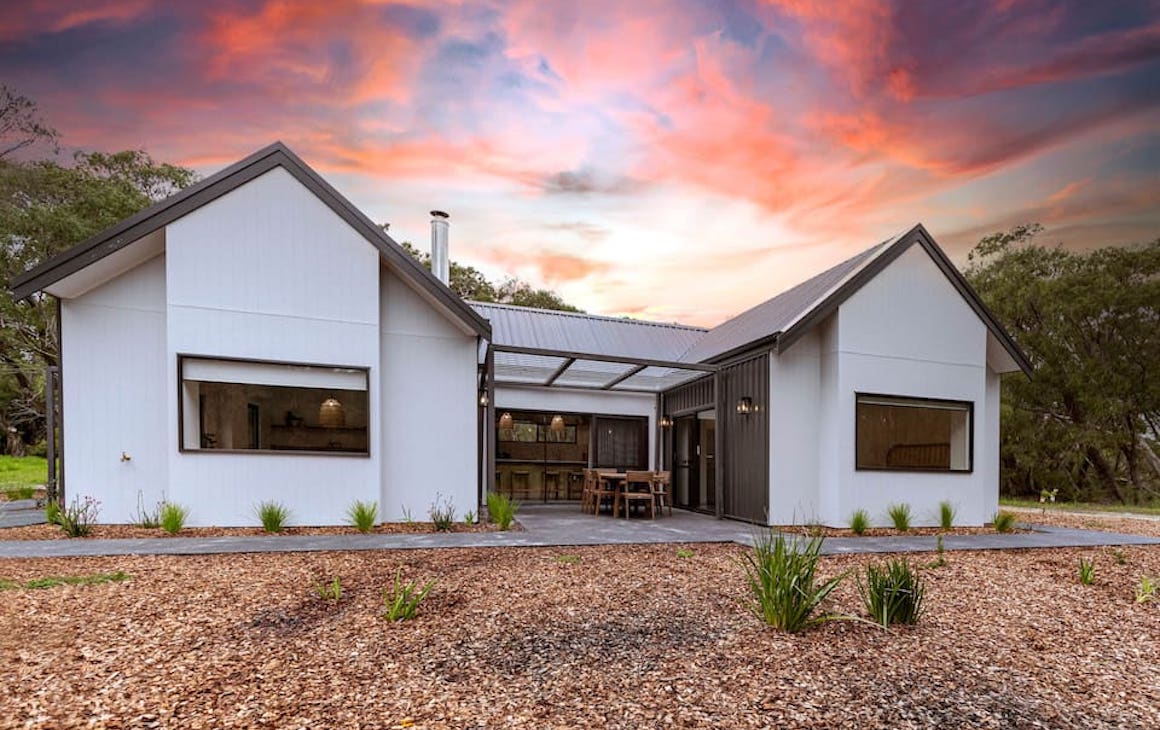 a chalet in Yallingup with a pink sky behind it