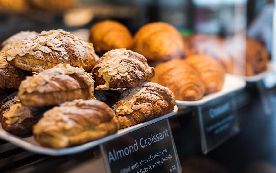 almond croissants stacked up in a display cabinet