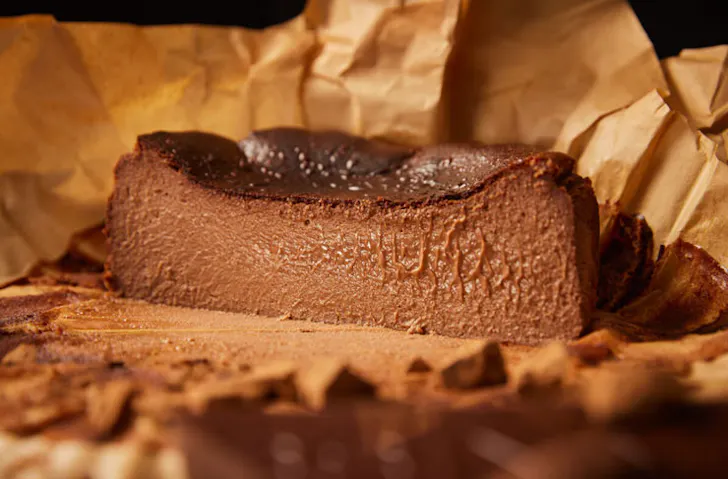 A chocolate burnt basque cheesecake sliced in half.