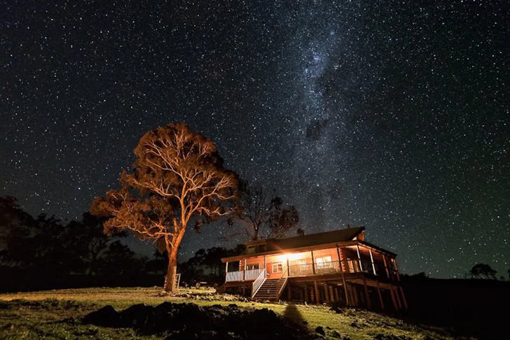 A log cabin under a starry night sky in NSW