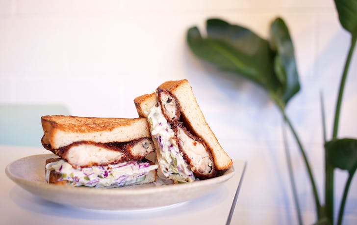 a chicken katsu sando cut in half on a plate