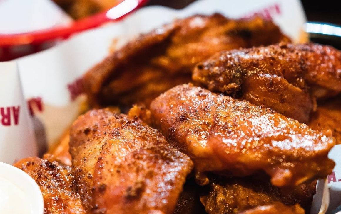 A basket filled with crispy chicken wings from Palace Arcade