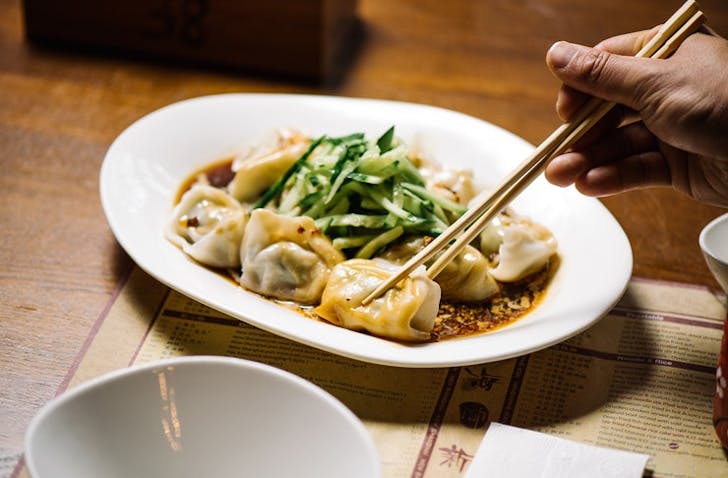 A chopstick picking up a dumpling at one of the best Chinese restaurants Melbourne has to offer.