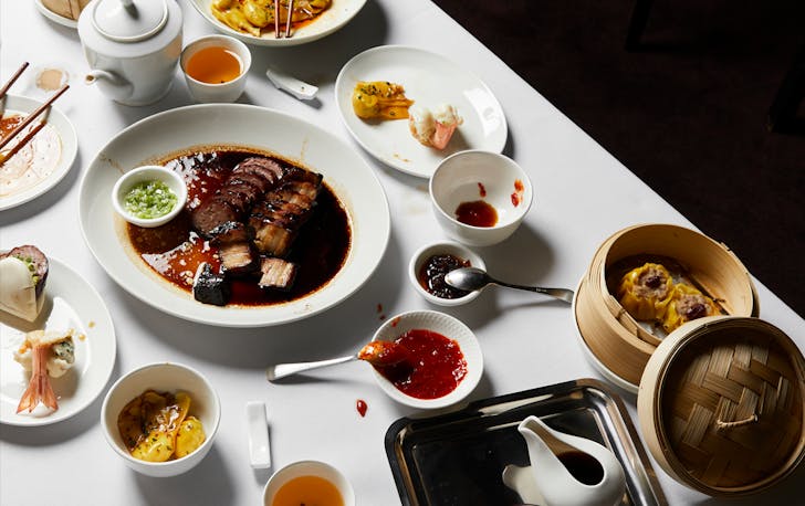 A white table with Chinese food, considered some of the best Chinese restaurants in Melbourne. 