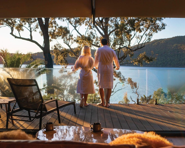 A couple on the deck of a glamping tent at Marramarra Lodge in NSW
