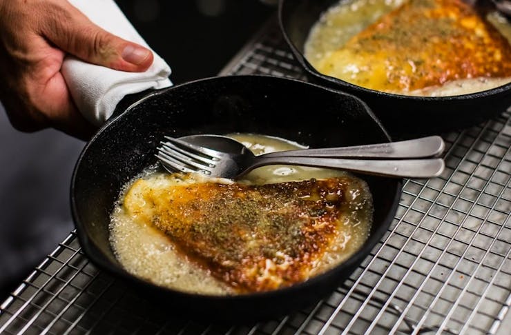 A cast iron pan with Saganaki cheese 
