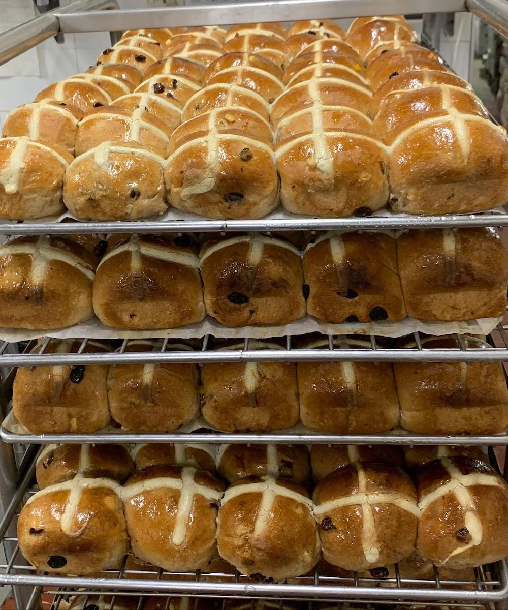 baking trays filled with hot cross buns